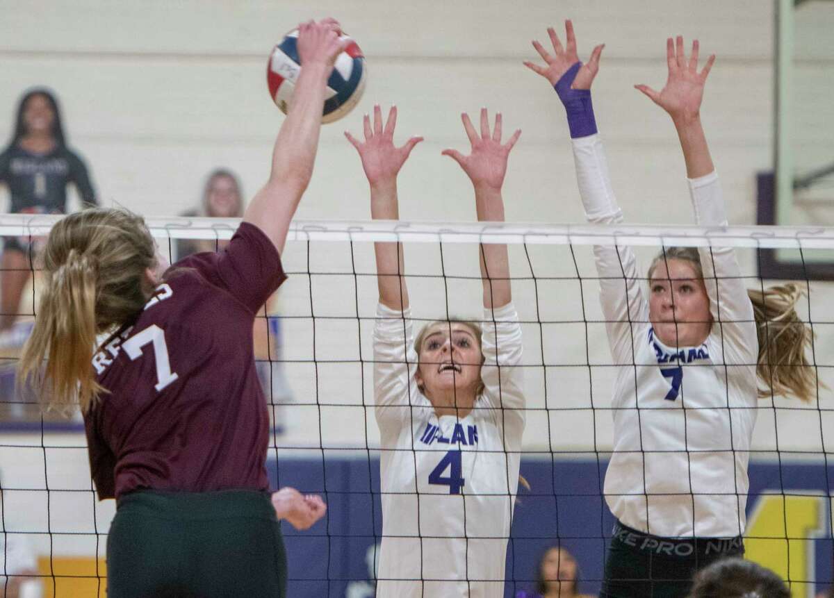 Legacy High's Kendall Harrington tries for a kill as Midland High's Grace Ware and Brooke Boehler try to block 09/28/2021 at the Midland High gym. Tim Fischer/Reporter-Telegram