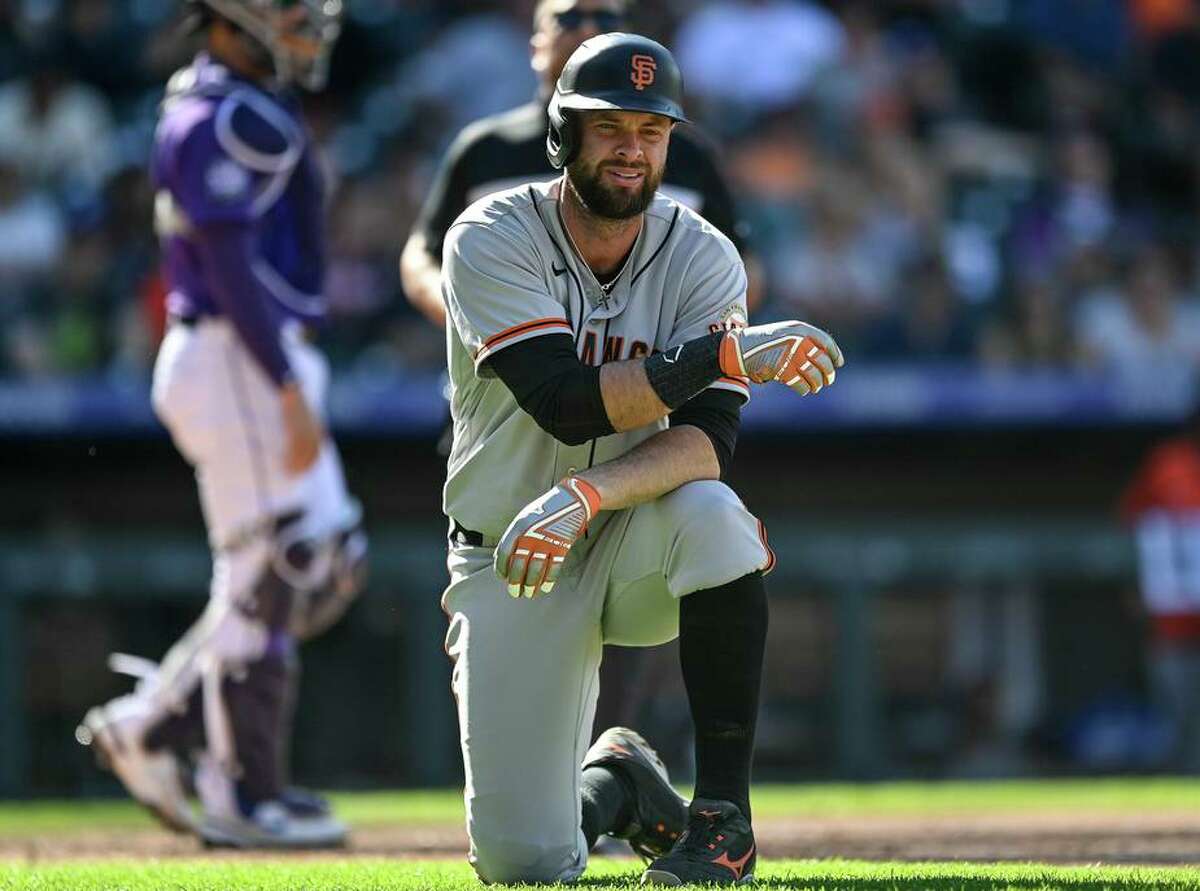 Giants first baseman Brandon Belt takes a knee after being hit by a pitch in the seventh inning against the Colorado Rockies on Sunday at Coors Field in Denver. Belt’s left thumb was broken on the play, and he’ll be out for an estimated four weeks.