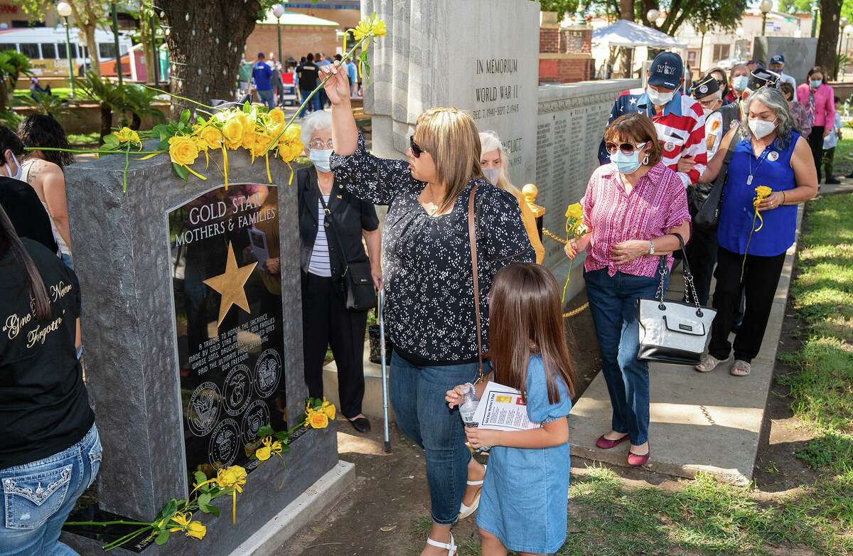 Familiares de Madres Estrella Dorada y de miembros del servicio caídos durante algún conflicto armado colocan flores en el recién erigido Monumento a las Madres Estrella Dorada, el sábado 25 de septiembre de 2021 en Jarvis Plaza.