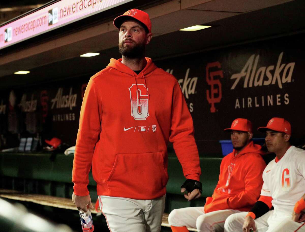 Brandon Belt (9) walks through the dugout wearing a brace on his thumb as the San Francisco Giants played the Arizona Diamondbacks at Oracle Park in San Francisco, Calif., on Tuesday, September 28, 2021.