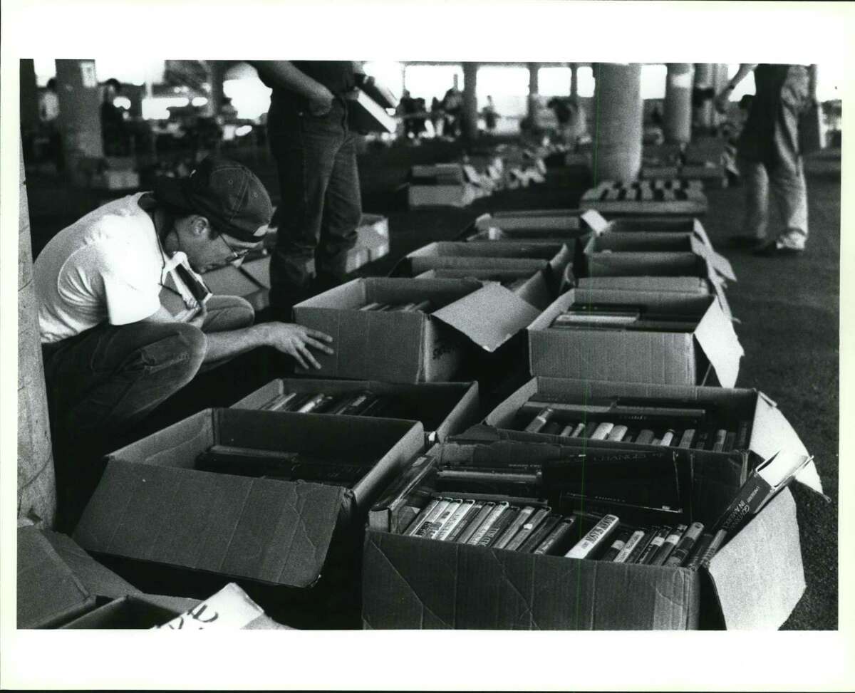 FILE PHOTO — Scott Power of San Antonio looks through boxes of books Sunday afternoon at the Friends of the San Antonio Public Library book sale at the old Sears parking garage.