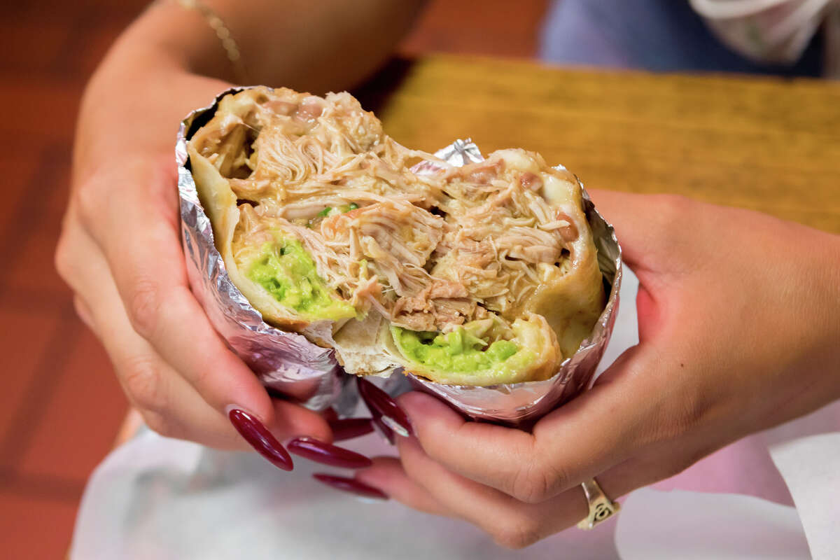 SFGATE burrito reviewer Cecilia Peña-Govea tries the super chicken burrito (dorado) at La Taqueria in San Francisco's Mission District.