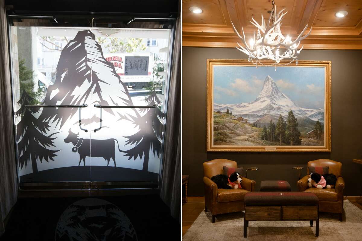 The door and a painting show pictures of the Matterhorn in the Matterhorn restaurant in San Francisco on September 28, 2021. The St. Bernard dogs Heidi and Otto sit on the chairs under the painting by Charlie Adam.