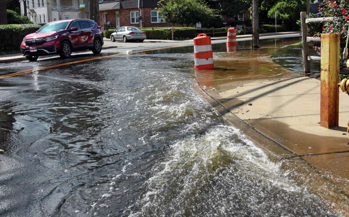 Water flows onto North Street partially flooding it as it is pumped out from an underground parking garage at The Wescott in Stamford, Conn., on Friday Sentember 3, 2021. The remnants of Hurricane Ida pummeled the region on Tuesday causing severe flooding in many spots.