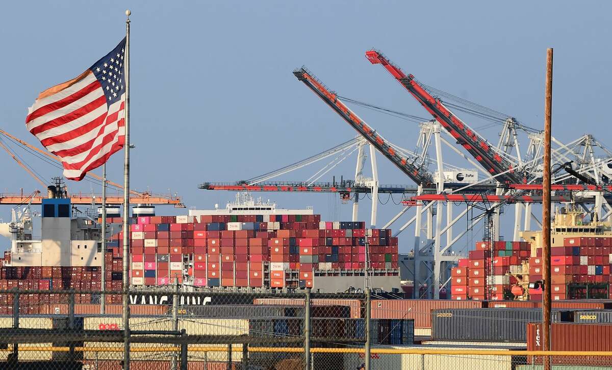 A US flag flies near containers stacked high on a cargo ship at the Port of Los Angeles on September 28, 2021 in Los Angeles, California. (Photo by FREDERIC J. BROWN/AFP via Getty Images)