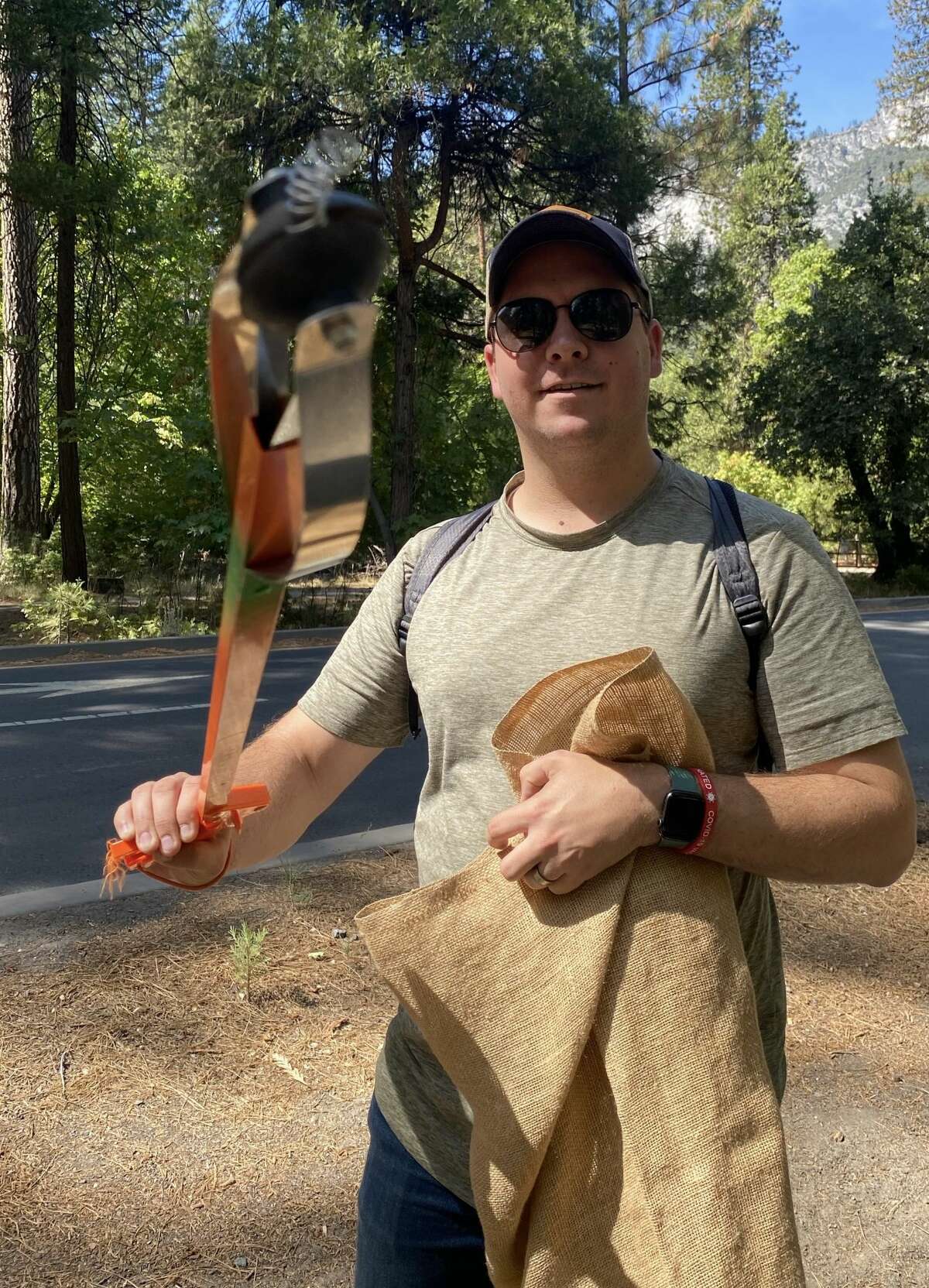 A volunteer shows litter he collected with a litter stick.