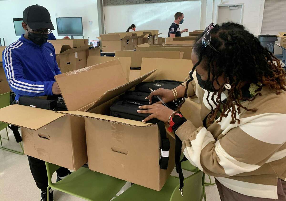 Howard McIntosh, 12, and his mother Kimberlin Hamilton search for his new Chromebook at Ponus Ridge STEAM Academy on Wednesday, Sept. 29, 2021. Each student at the middle school received a new device through a partnership with Verizon Innovative Learning.