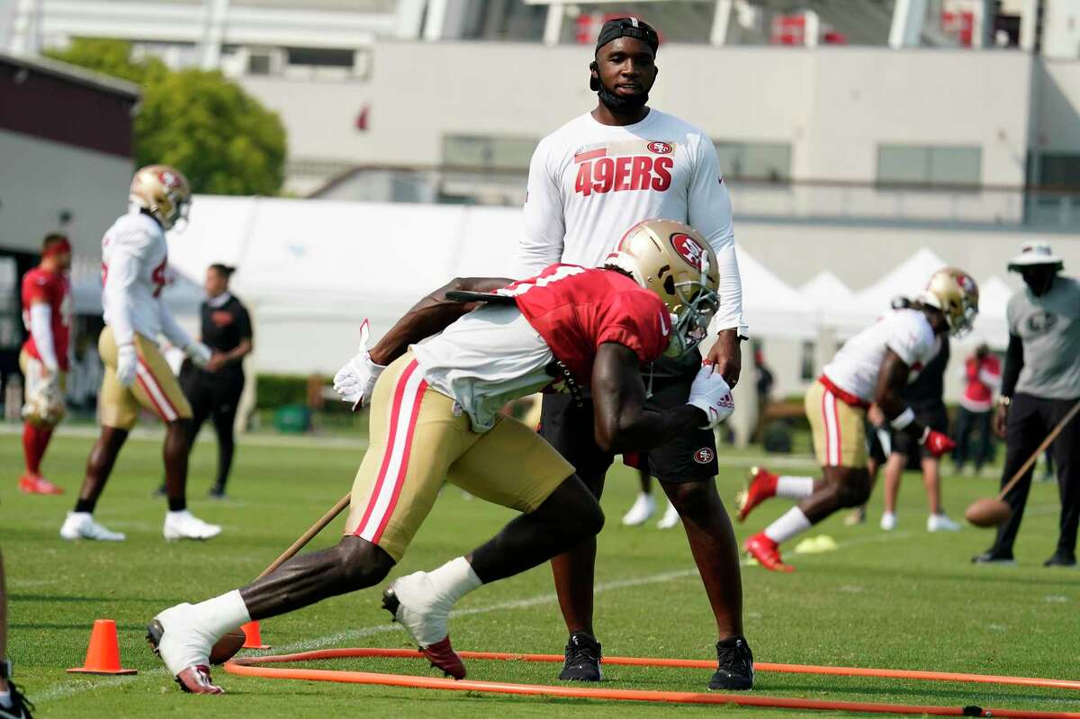 San Francisco 49ers defensive coordinator DeMeco Ryans looks up at