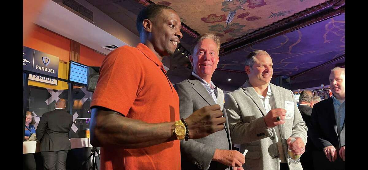 Gov. Ned Lamont with former NFL players Darius Butler and Wayne Chrebet during a celebration at Mohegan Sun casino to officially launch sports gambling in Connecticut.