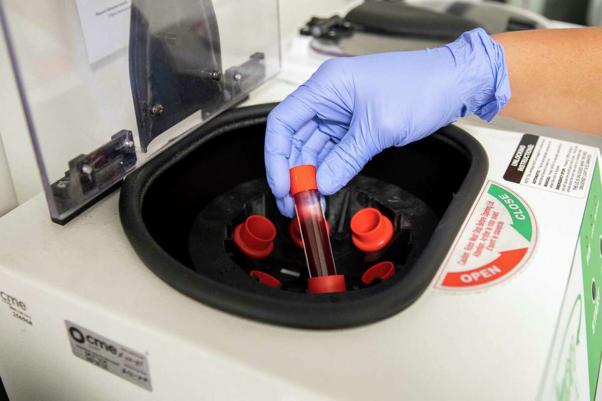 Wu takes blood work to a centrifuge at Carbon Health in Oakland, Calif. on Friday, Sept. 24, 2021. The clinic enrolled patients in late-stage clinical trials for oral anti-viral pills made by Merck that attempt to prevent or treat the symptoms of COVID-19 from people infected with the novel coronavirus.
