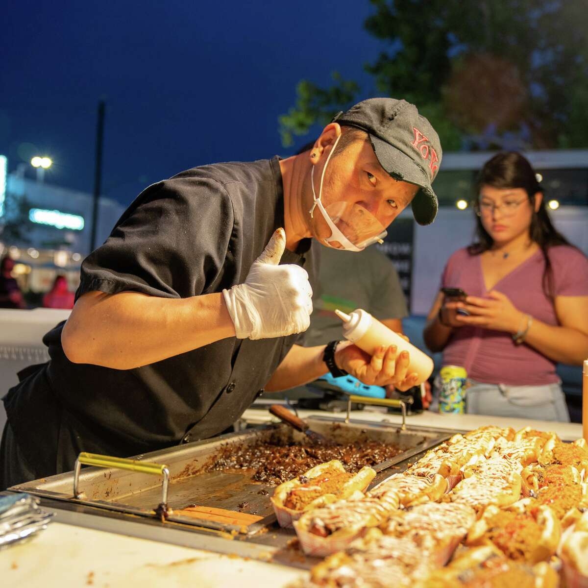 Danny "Yoyo" Kim serves and cooks hotdogs from his eponymous hot dog cart in Rice Village.