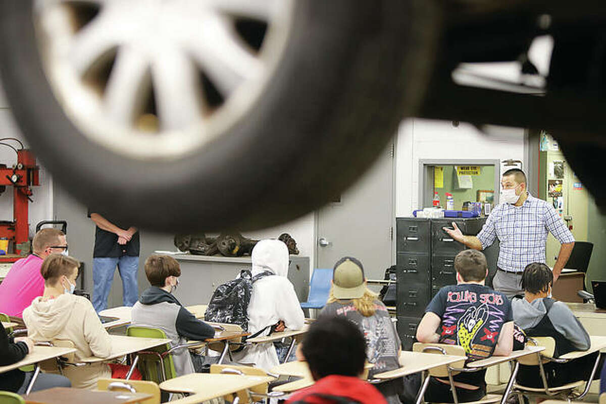 Chris Mathus, right, a Ford Motor Company Field Service Engineer from Earth City, Missouri, and a former Alton High School automotive vocational student, talks to students in an automotive repair class Wednesday at AHS. Ford service reps and managers from Roberts Motors were at the school for Ford Day.