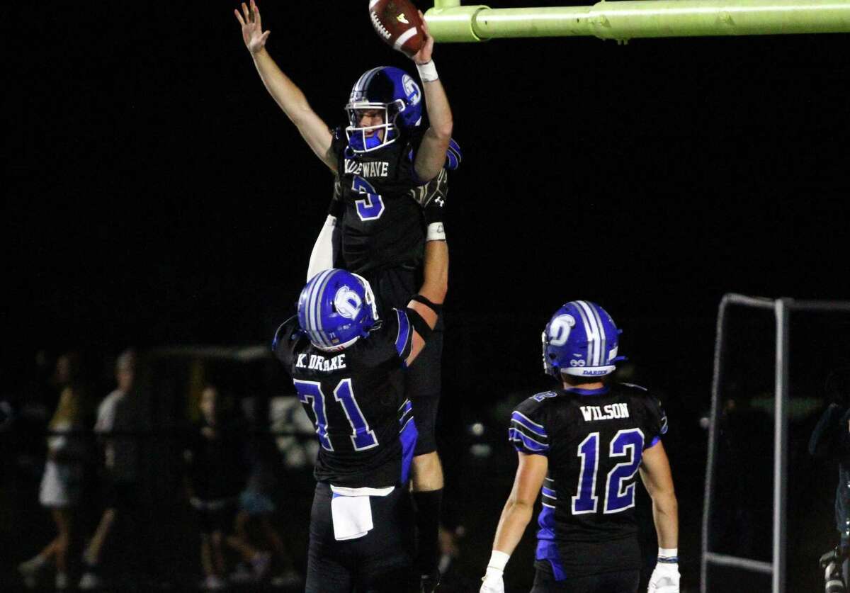 Darien's Miles Drake (3) leaps into the arms of teammate Karson Drake (71) after scoring a touchdown during high school football action against Newtown, in Darien, Conn., on Friday September 18, 2021.