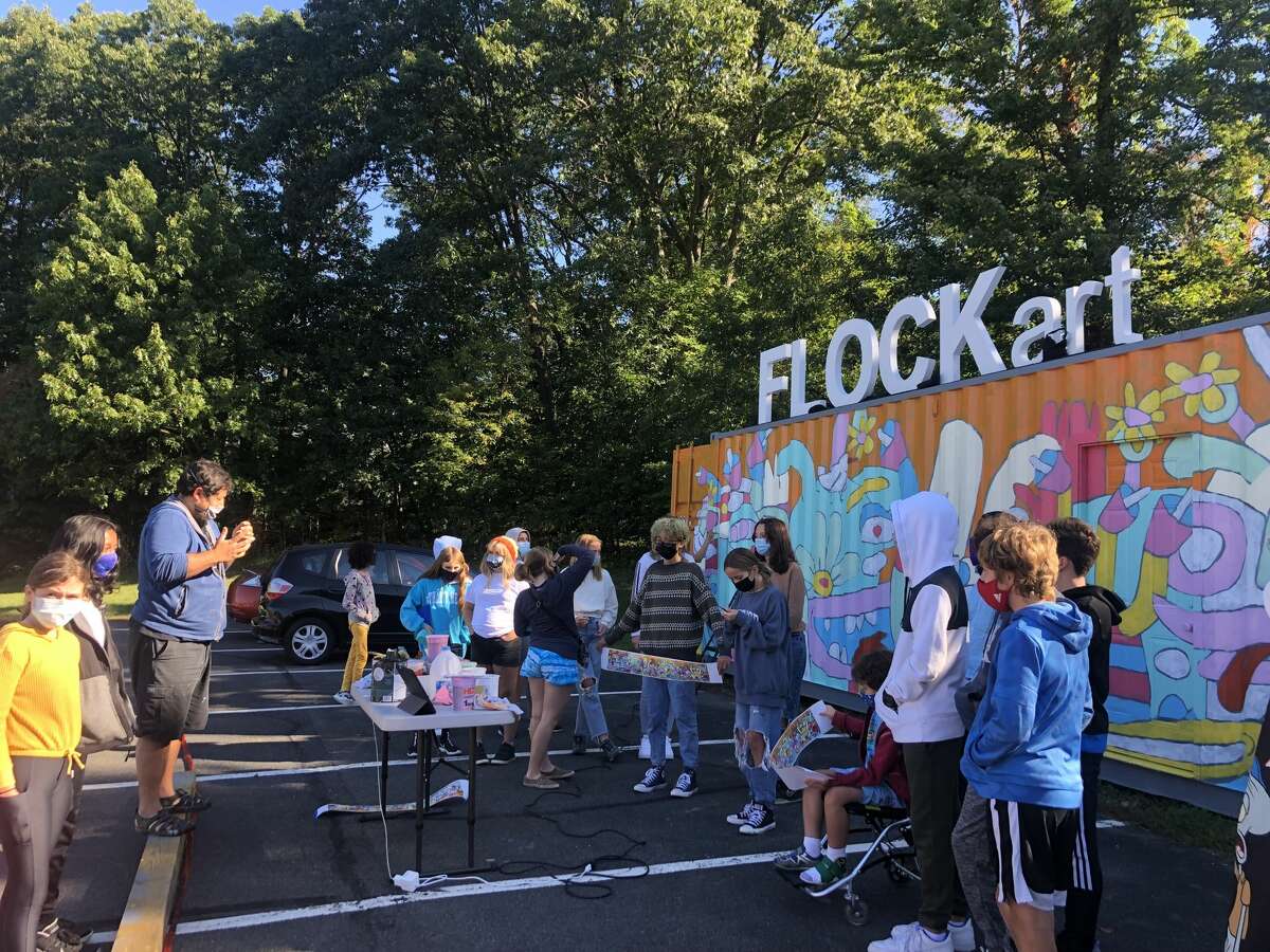 Students of Woodland Hill Montessori School in North Greenbush watch as artist Fernando Orellana paints the FLOCKart mural.