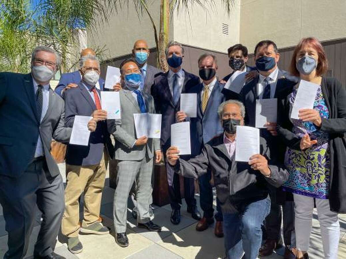 A mostly male crowd attends Gov. Gavin Newsom’s signing of a package of affordable housing bills at the Coliseum Connections apartment complex in Oakland last month.