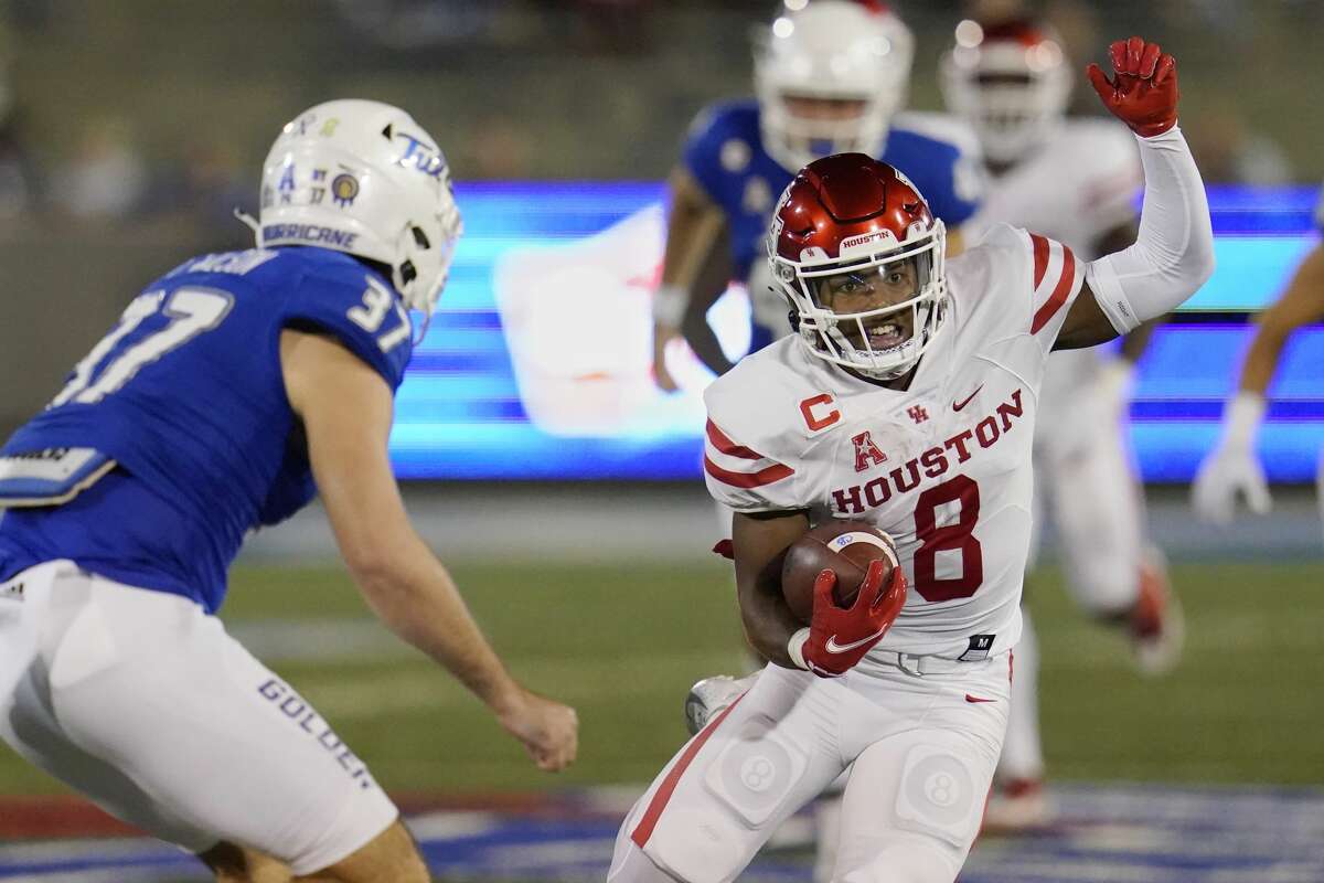 Houston running back Chandler Smith (8) carries past Tulsa safety Hunter Rangel (37) in the first half of an NCAA college football game Friday, Oct. 1, 2021, in Tulsa, Okla. (AP Photo/Sue Ogrocki)