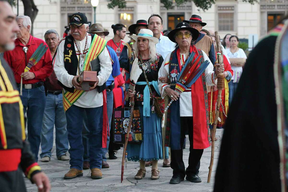 Ramón Vásquez y Sánchez (from right), his wife Maria Chavez Vásquez and Raymond Hernandez form a line as local Native Americans gather to honor buried descendants during their 25th Annual Sunrise Ceremony at the Alamo on Saturday, Sept. 7, 2019. In the background is the Hipolito F. Garcia Federal Building, where the first church of the Mission San Antonio de Valero may have been.