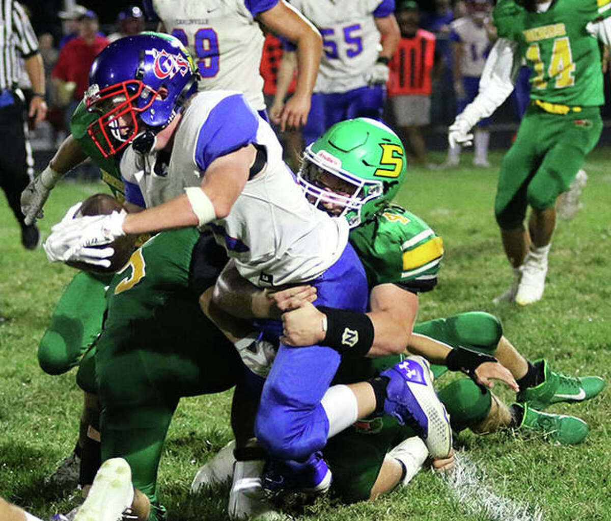 Carlinville’s Jake Schwartz is tackled by Southwestern’s Blake Funk in a South Central Conference football game Friday night at Knapp Field in Piasa.