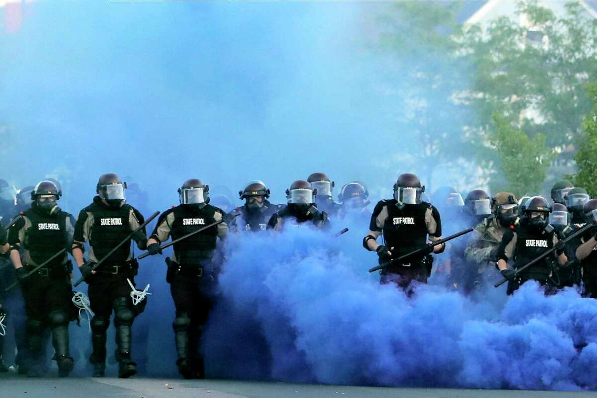 Minnesota State Police officers approach protesters last year in Minneapolis. The Minnesota State Patrol purged emails and texts messages immediately after their response to protests in the wake of George Floyd’s death last summer, according to court testimony in a lawsuit that alleges the state patrol targeted journalists during the unrest.