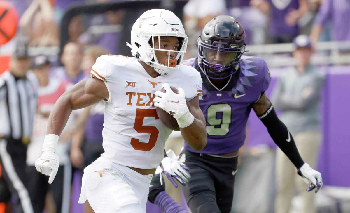 Texas running back Bijan Robinson (5) runs for a touchdown as TCU cornerback C.J. Ceasar II (9) pursues during the first half of an NCAA college football game Saturday, Oct. 2, 2021, in Fort Worth, Texas. (AP Photo/Ron Jenkins)