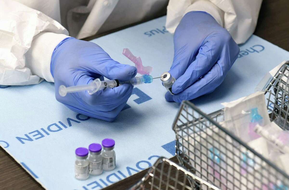 A pharmacist handles vials of the Pfizer-BioNTech COVID-19 vaccine, in a file photo.