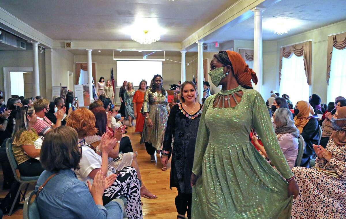 Models walk down the makeshift runway at the fashion show organized by Catholic Charities to showcase the work of Afghan seamstresses who have immigrated to the United States.