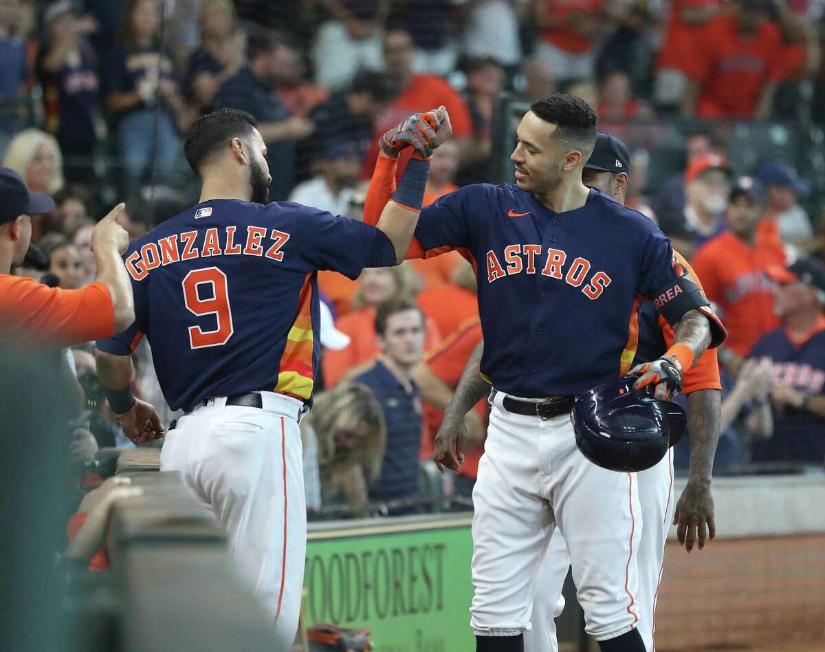 Houston Astros Carlos Correa (1) celebrates with Marwin Gonzalez after hitting a home run off of Oakland Athletics relief pitcher Domingo Acevedo during the eighth inning of an MLB baseball game at Minute Maid Park, Sunday, October 3, 2021, in Houston.