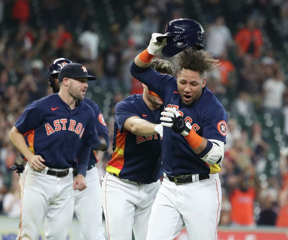 Houston Astros Yuli Gurriel (10) is mobbed by teammates after his single off of Oakland Athletics relief pitcher Lou Trivino scored Jason Castro for the game winning run during the ninth inning of an MLB baseball game at Minute Maid Park, Sunday, October 3, 2021, in Houston.