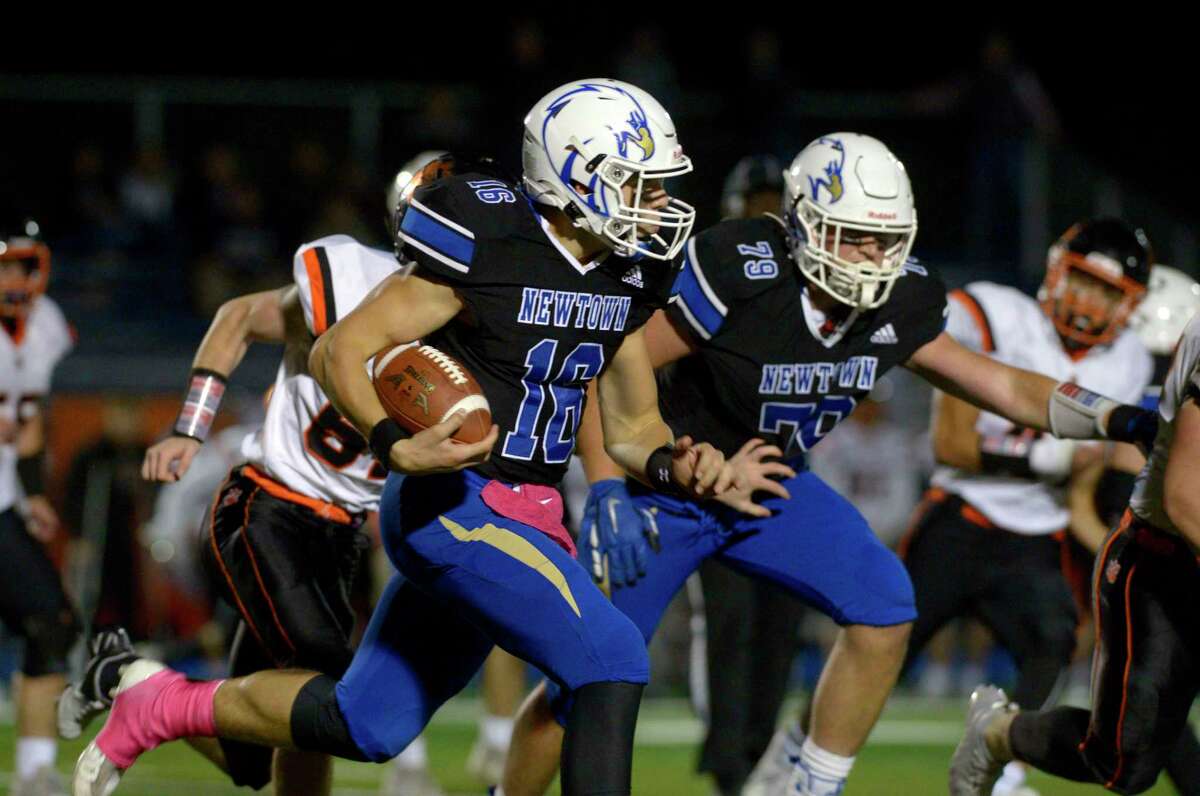 Newtown's Dylan Magazu (16) cuts through the line in the high school football game between Ridgefield and Newtown high schools. Friday night, October 1, 2021, at Newtown High School, Newtown, Conn.