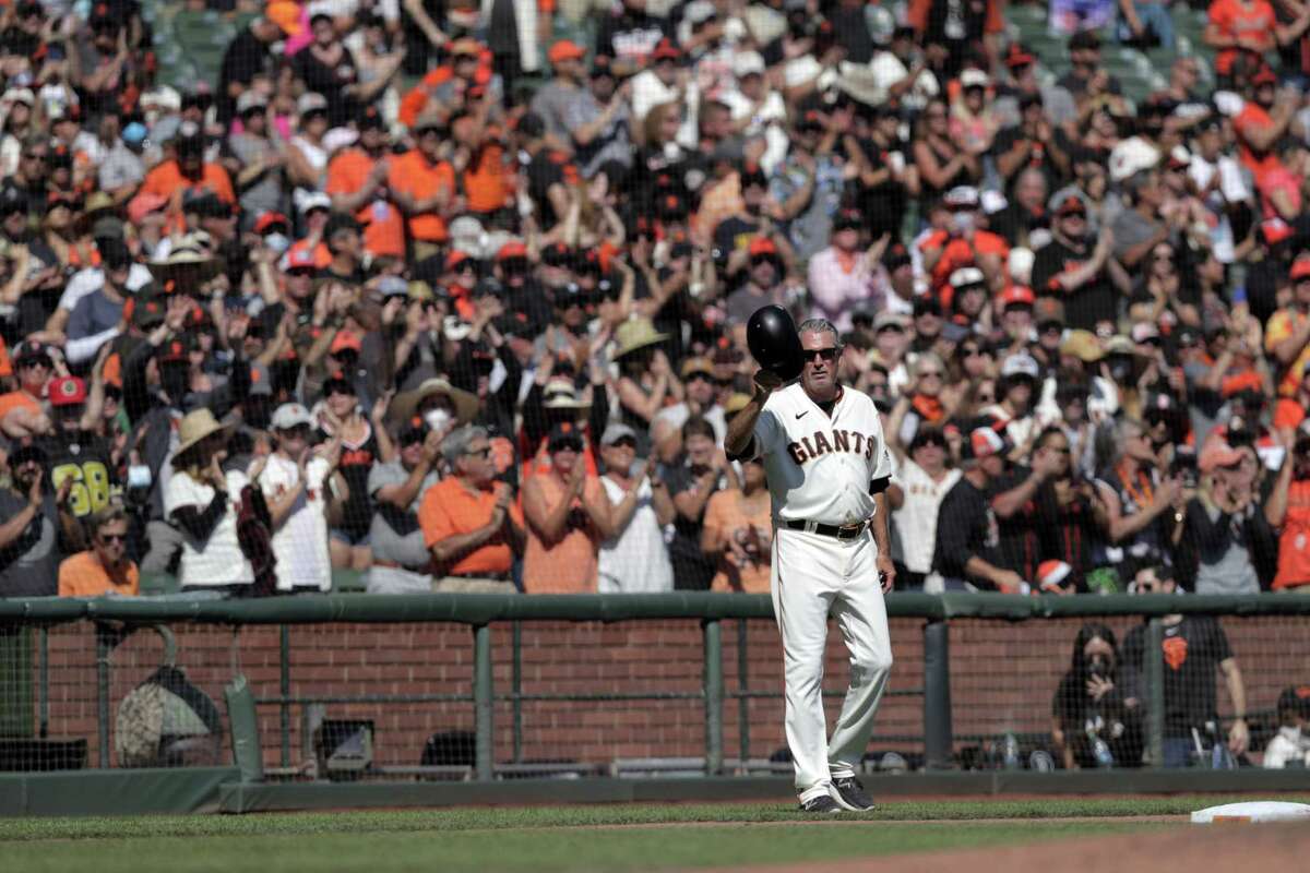 Giants third base coach Ron Wotus (8) tips his cap to the fans after he was honored by the team in the fourth inning as the San Francisco Giants played the San Diego Padres at Oracle Park in San Francisco, Calif., on Sunday, October 3, 2021.