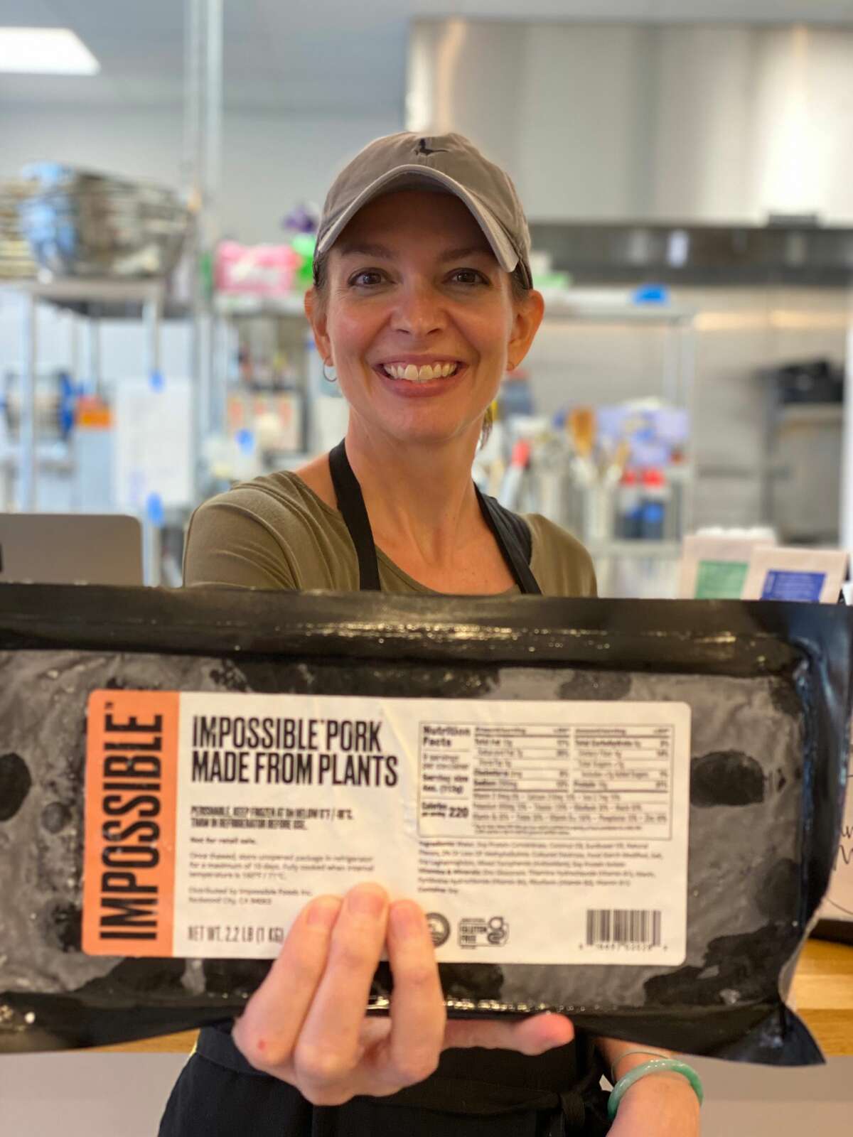 Stacy Nguyen, who owns Banh MI 47 in Albany with her husband, Mike, holds a package of Impossible Foods new plant-based "pork" product.