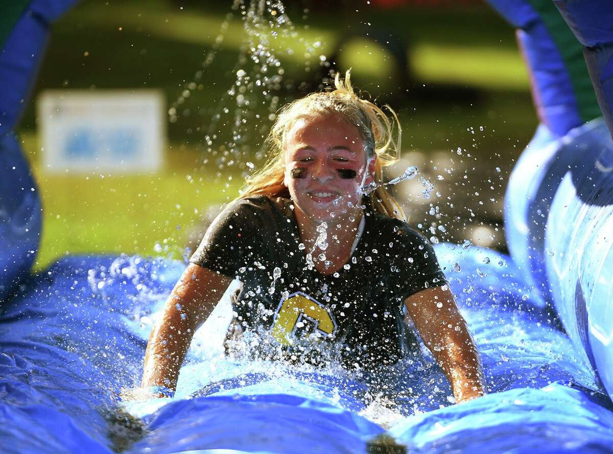 Mia Jones, 13, of Darien, slides through the final obstacle on her way to the finish of the 9th Annual Muddy Up 5k run put on by the Boys and Girls Club of Greenwich at Camp Simmons in Greenwich, Conn. on Sunday, October 3, 20i21.
