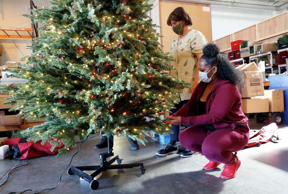 Tiffany Stuart (front) and Susanna Hnilo construct a Christmas tree at Balsam Hill, which is paying 270% more to import decorations.