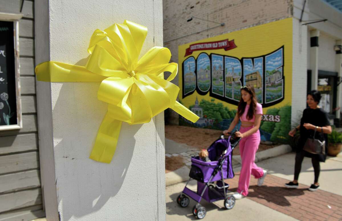 Charlotte and Maribel Patton, along with their dogs CoCo and BooBoo, walk past the yellow ribbons displayed prominently on Main Street in Boerne to remember the 13 U.S. service members who were killed at the Kabul airport in late August and to keep up hope for the Americans who are still there.