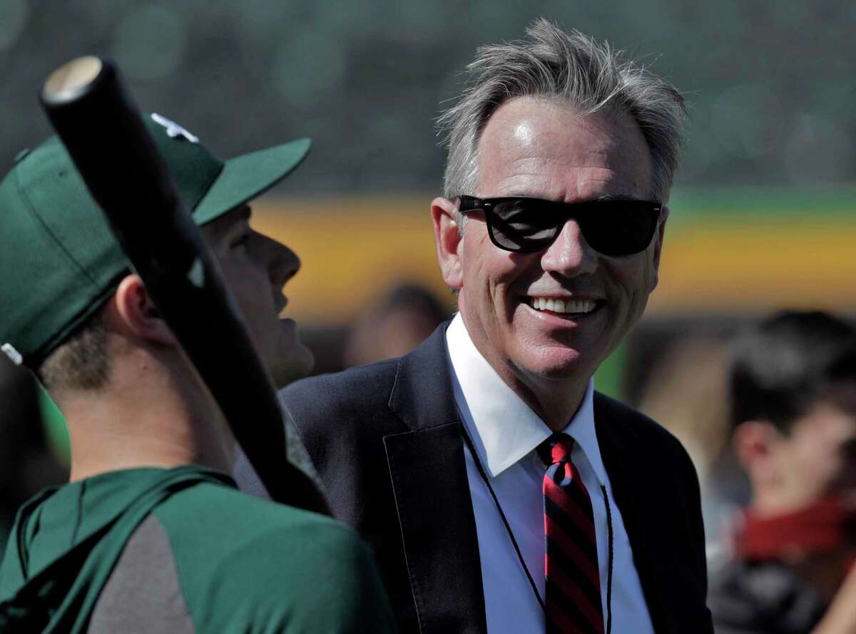 Billy Beane chats wtih Matt Chapman (26) before the Oakland Athletics played the Tampa Bay Rays at the Oakland Coliseum in the Wild Card playoff game in Oakland, Calif., on Wednesday, October 2, 2019.