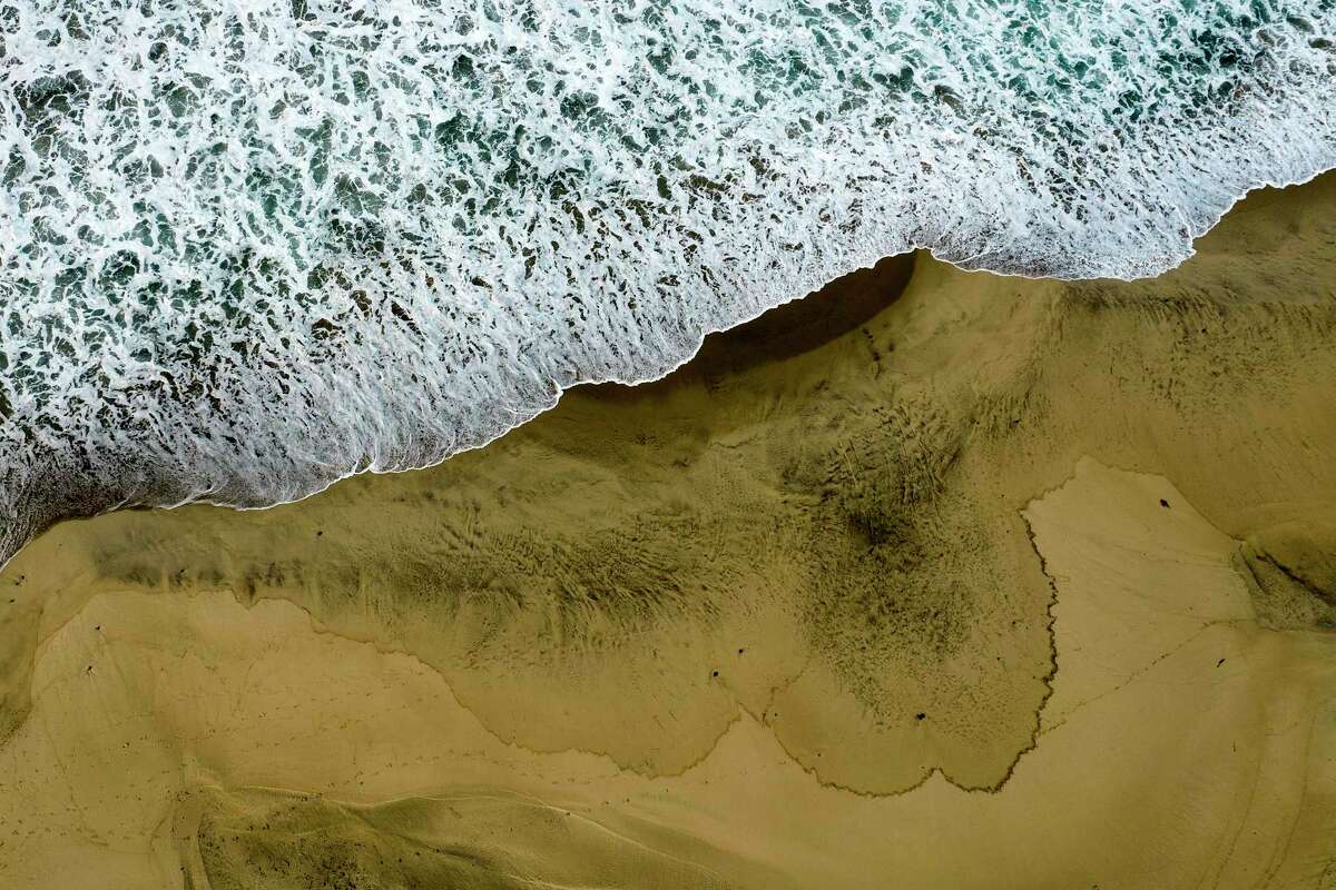 An aerial photo shows the closed beach after oil washed up on Huntington Beach, Calif., on Monday, Oct. 4, 2021.
