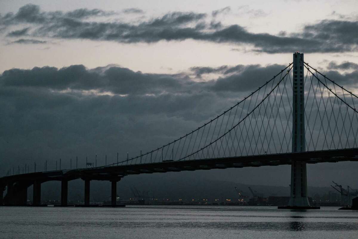 The Bay Bridge is seen with large clouds looming over the East Bay as seen from Treasure Island on January 27, 2021. Cloudy skies, cooler temperatures and possibly some rain are in the forecast for this week.