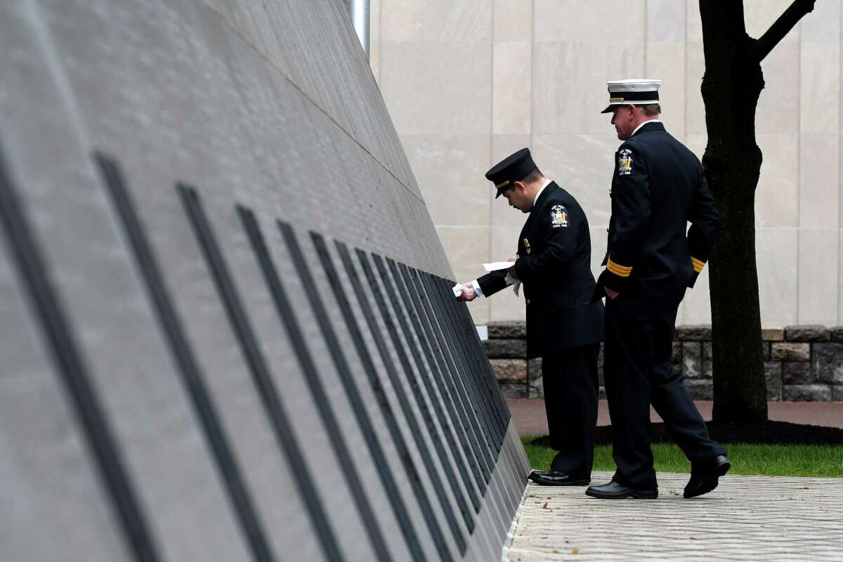 Joe Marini, a fire protection specialist with New York State Fire, dries the names of firefighters who were recently added to the New York State Fallen Firefighters Memorial on Tuesday, Oct. 5, 2021, at Empire State Plaza in Albany, N.Y. Twenty-four names were added to wall this year, including Donald G. Thomas of the Ballston Spa Fire Department. Last year?•s ceremony honoring twenty-one fallen firefighters was postponed due to the pandemic. Michael G. Miles of Albany County with the NYS Office of Fire Prevention and Control was added in 2020.