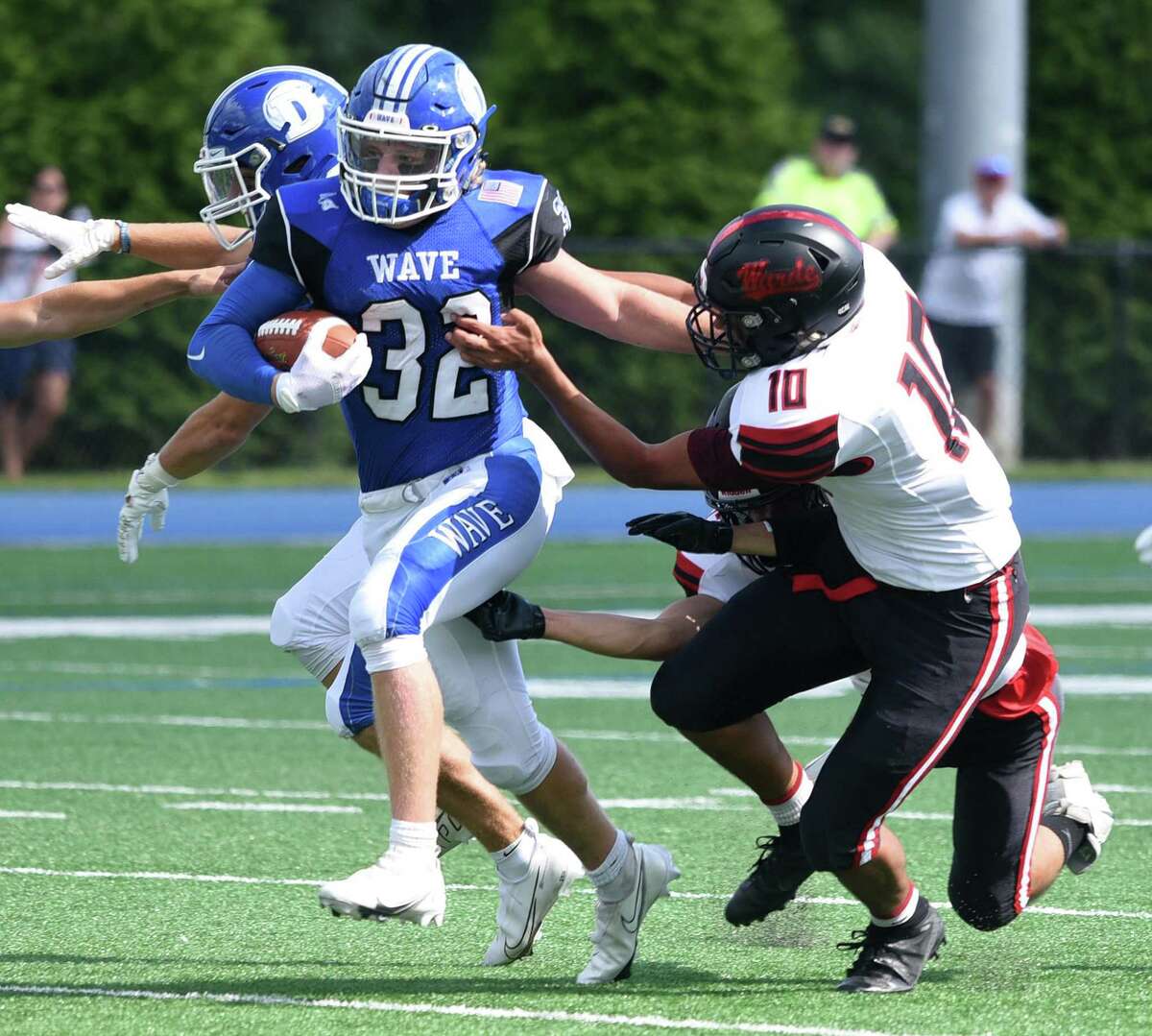 Darien running back Tighe Cummiskey (32) battles Warde's Anwar Sakly (10) during a football game at Darien High School on Sat., Sept. 11, 2021.