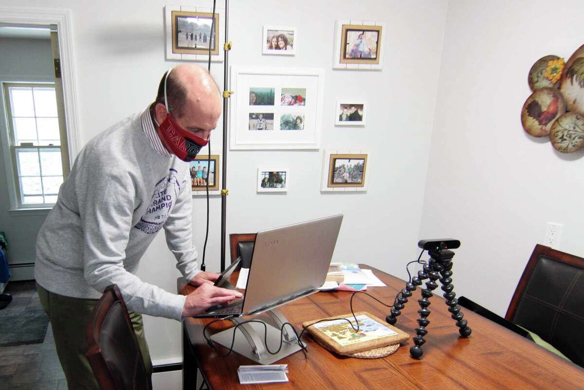 Paul Doyle, who helps his wife Susan use Zoom to broadcast her show: Downsized Gourmet, sets up equipment in the kitchen at their home in Stamford, Conn., on Tuesday October 5, 2021. Due to the COVID-19 pandemic, in June of 2020 Susan started the cooking show and invited members of several senior centers and facilities to tune in. Their work has culminated in a cookbook which will raise money for the Fairfield County Walk to End Alzheimer's slated for Sunday October 10th.