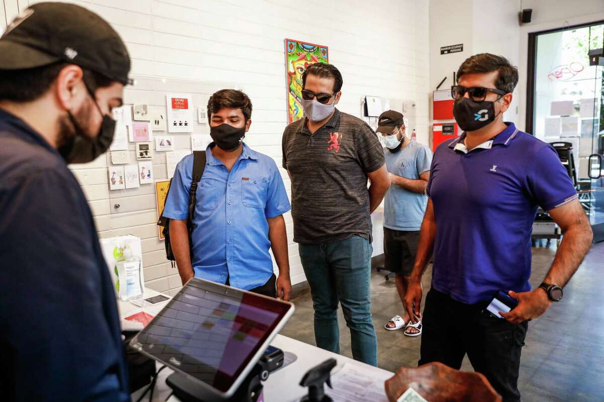 Rameel Farooqi (left) takes an order at Zareen’s restaurant in Redwood City. Some Bay Area counties are signaling that they could soon ease up on indoor mask requirements for vaccinated people.
