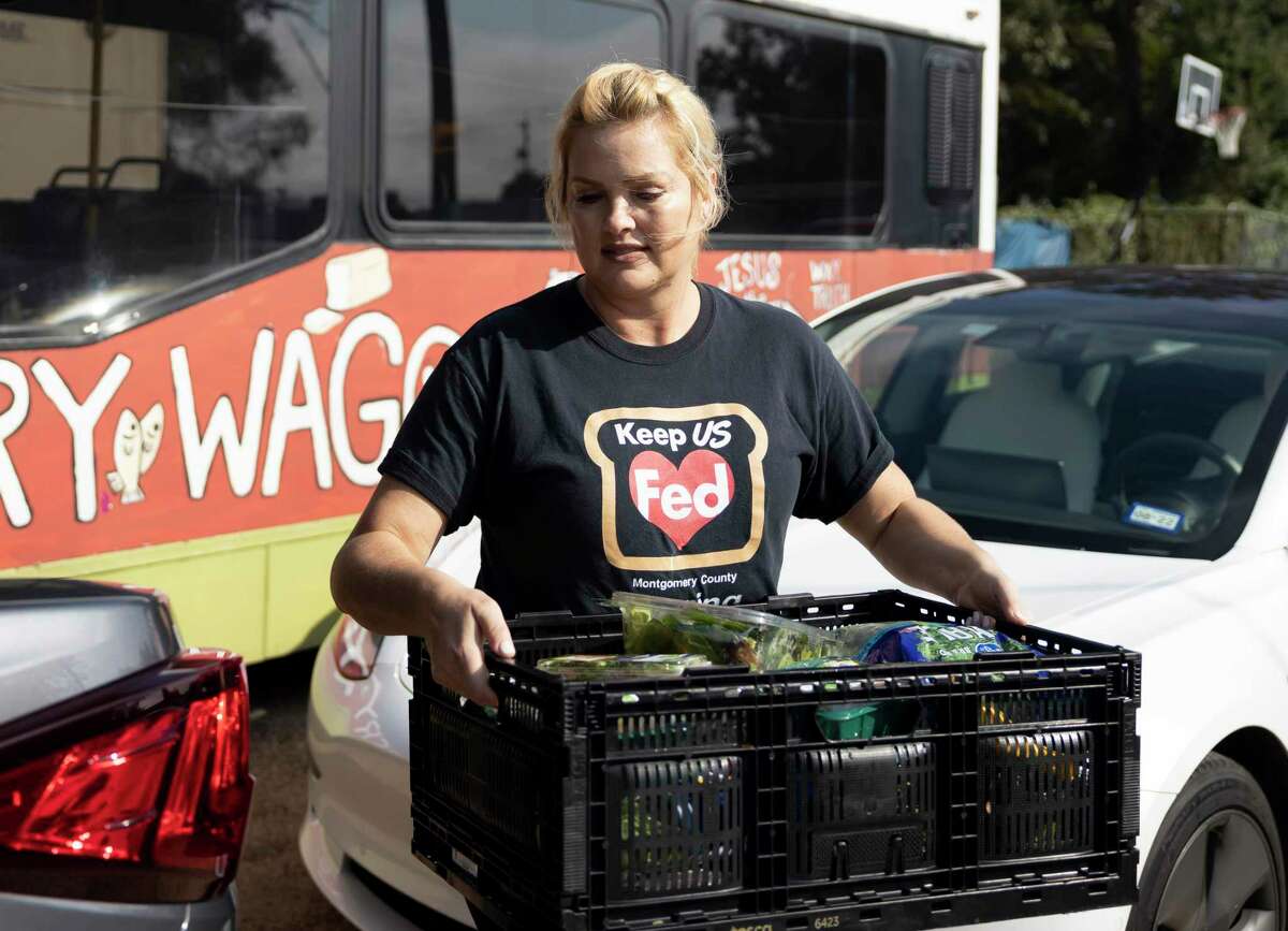 Tiffany Baumann Nelson, executive director of Keep US Fed Montgomery County, unloads a crate of food from the back of her vehicle during a food donation delivery by Keep US Fed Montgomery County at Under Over Fellowship, Thursday, Sept. 30, 2021, in Conroe. Nelson is a breast cancer survivor who was partially inspired by her cancer journey to get involved with philanthropy and start her own organization.