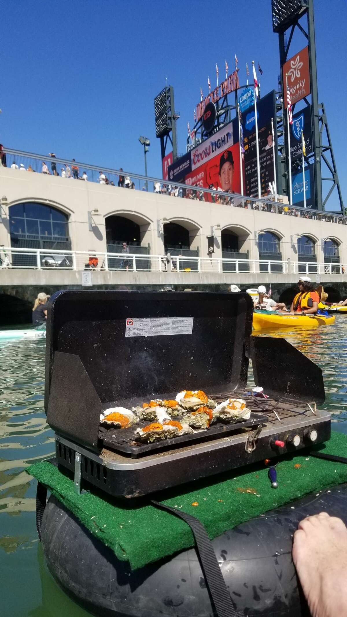 Brian Casey barbecues oysters on his AmphiBBQ during the Sunday San Francisco Giants game in McCovey Cove. 