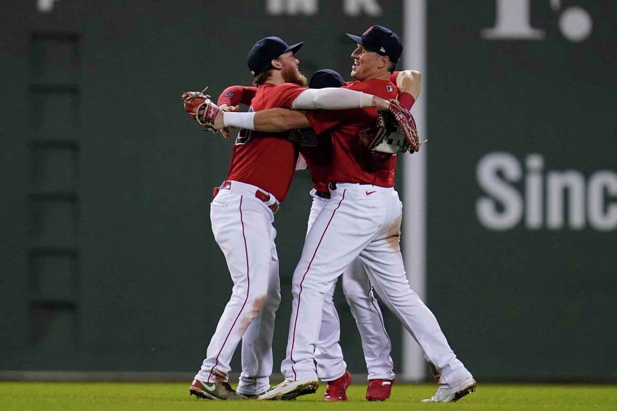 Boston Red Sox outfielders Alex Verdugo, left, and Hunter Renfroe, right, celebrate after they defeated the New York Yankees 6-2 in an American League Wild Card playoff baseball game at Fenway Park, Tuesday, Oct. 5, 2021, in Boston. (AP Photo/Charles Krupa)