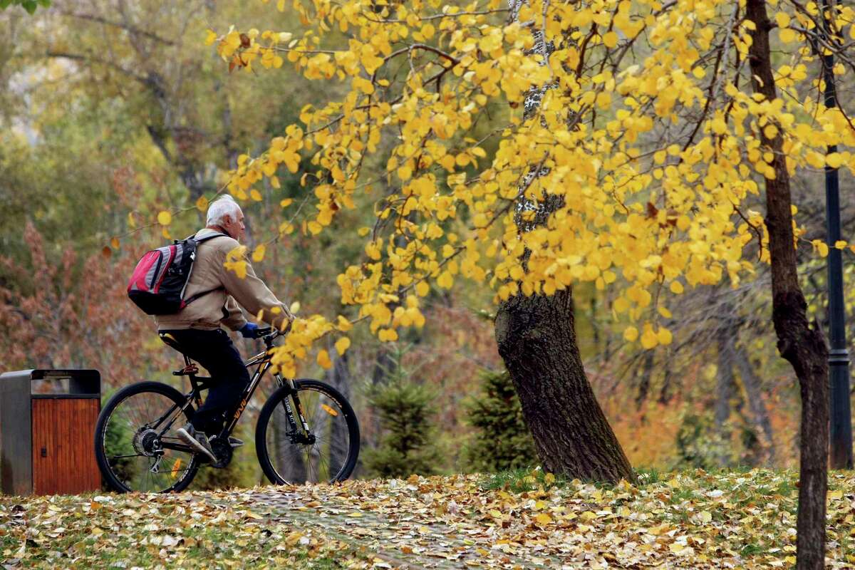 A senior citizen rides a bicycle in a park in Ukraine in fall 2018. (Photo by Ovsyannikova Yulia / Barcroft Media via Getty Images)