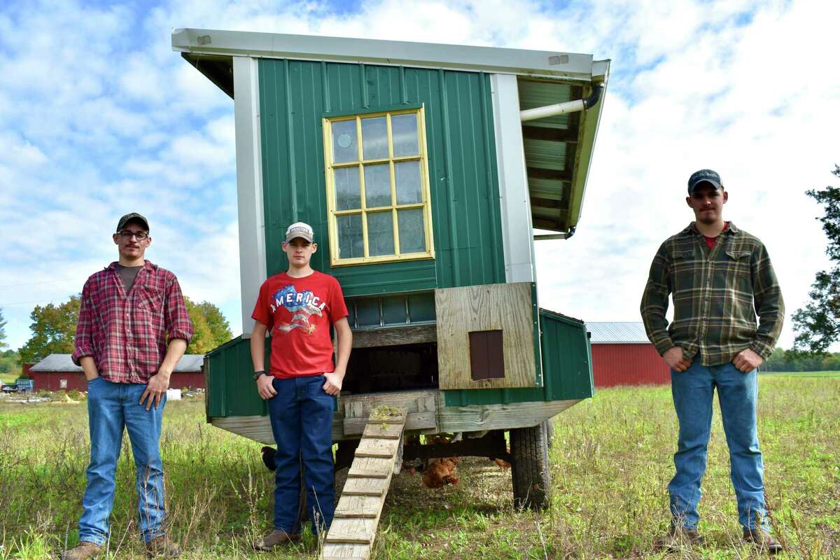 Brothers Sawyer, Scott and Jarrad Stilson help with work on their family farm which often includes upkeep of the farm's movable chicken coop. (Pioneer photo/Olivia Fellows)