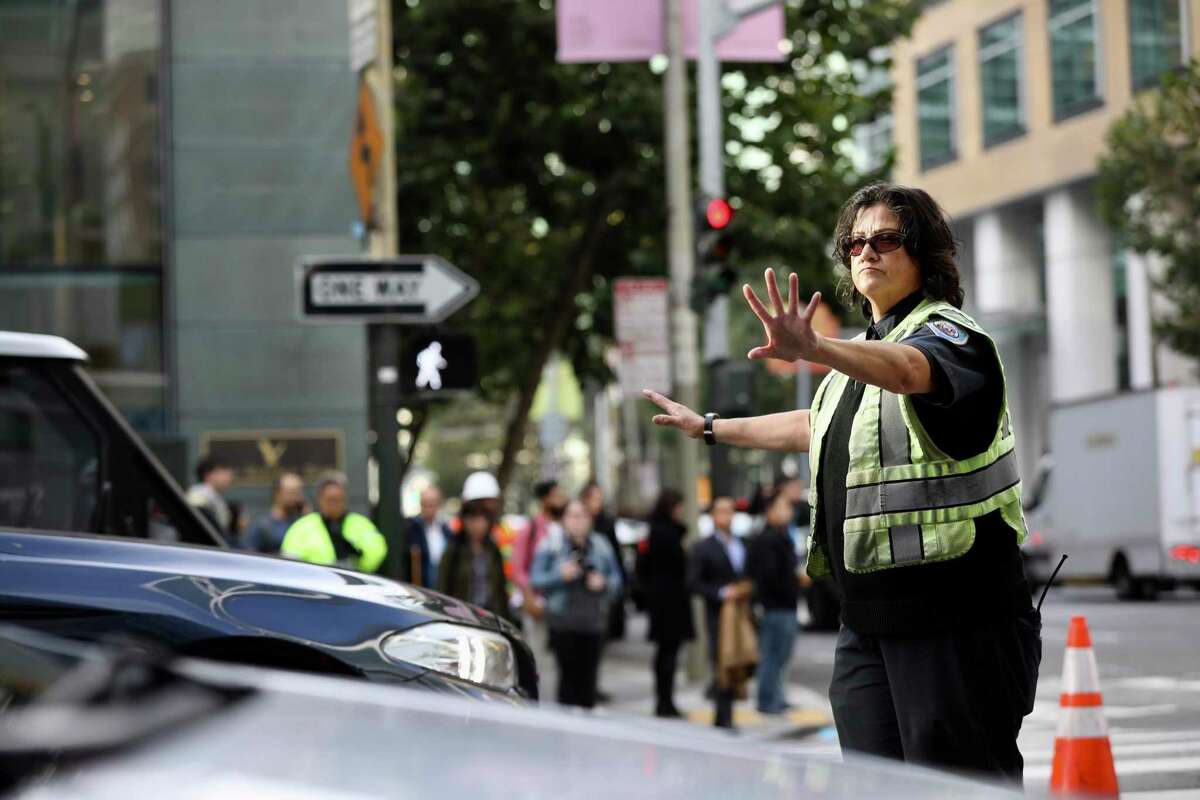 A traffic enforcement officer directs cars at Fremont and Howard near the Transbay transit center in 2018. A string of popular events will converge in downtown San Francisco this weekend, with Giants playoff games drawing crowds to Oracle Park as fans of the Blue Angels air show pack Crissy Field and Pier 39.