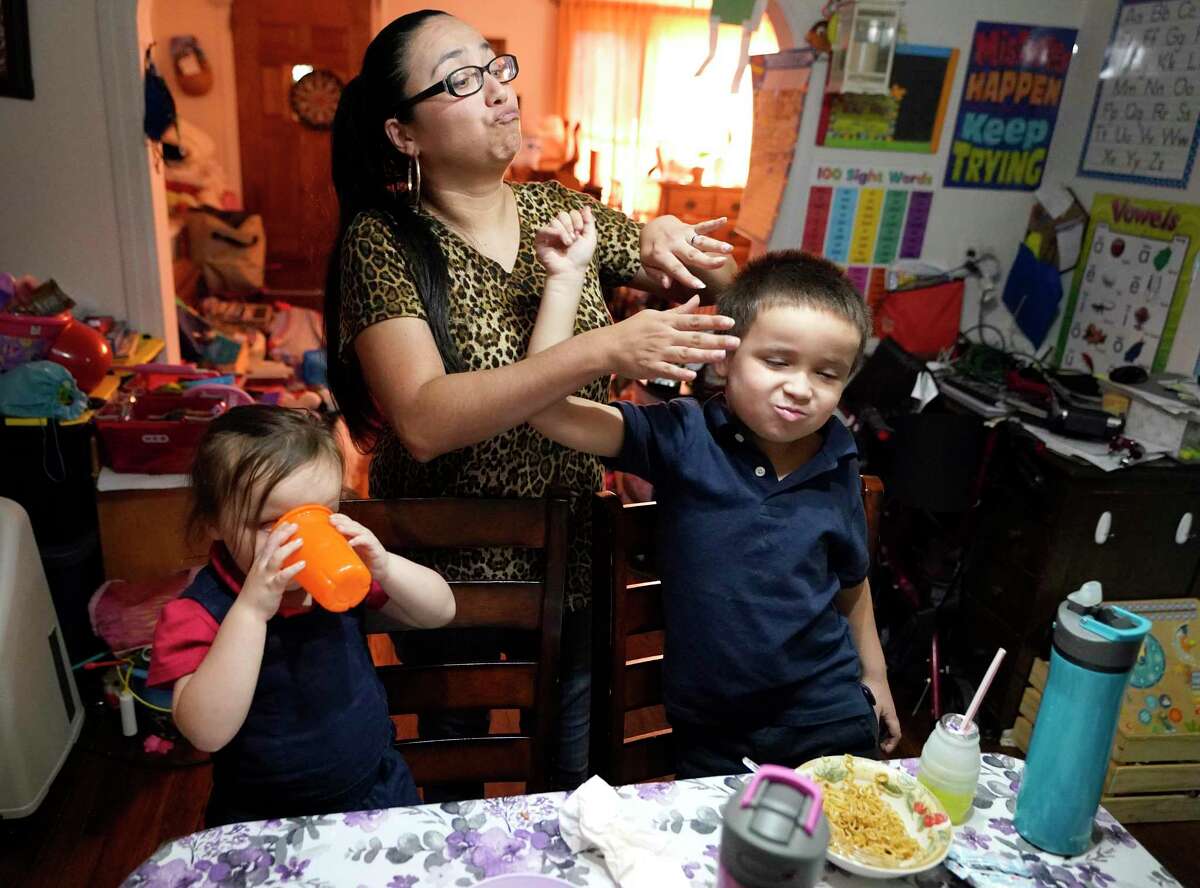 Yrsa Becker, 4, shown left, as her mother, Brittaney Becker, and her bother, Malachi Becker, 6, have a playful exchange while they eat dinner Friday, Sept. 24, 2021 in Houston. Brittaney and her husband, Brandon Becker, discussed the difficulties the family has faced during the COVID-19 pandemic shown Friday, Sept. 24, 2021 in Houston. They had to moved in with Brittaney’s grandmother.