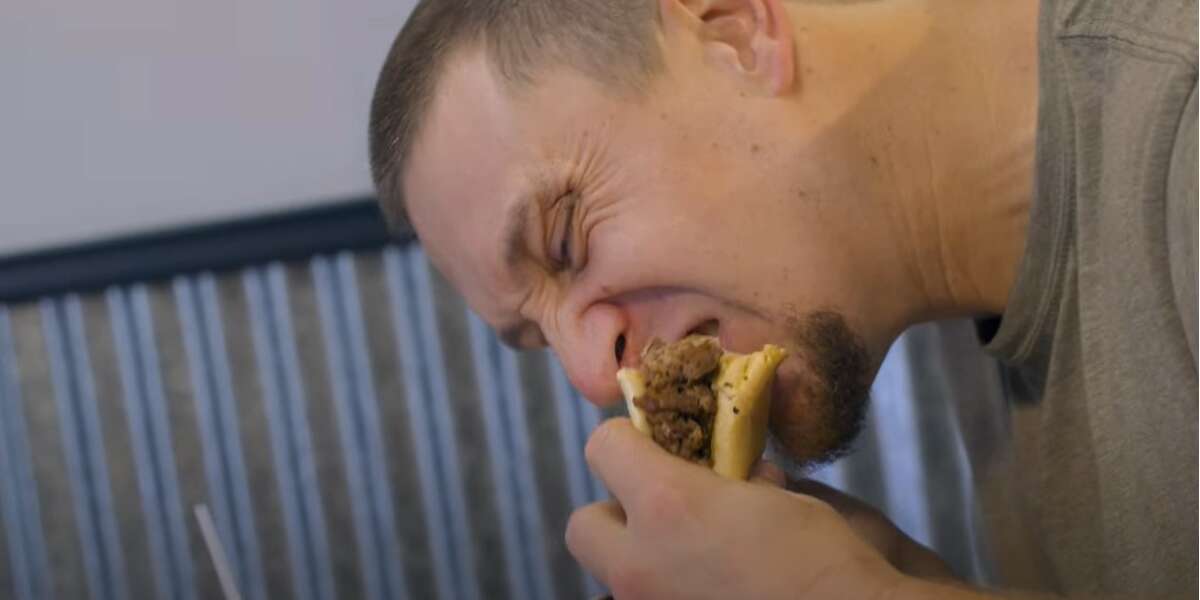 San Francisco Giants outfielder Alex Dickerson chomps into a cheesesteak from the Cheese Steak Shop.