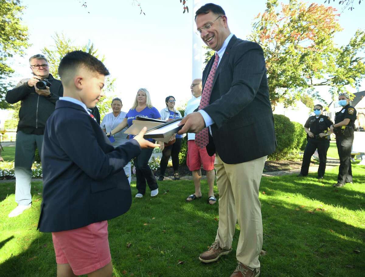 Make a Wish recipient Anthony Muoio, 7, of Milford, receives a proclamation from Mayor Ben Blake during a city ceremony and WPLR radio interviews on The Green in Milford, Conn. on Thursday, October 7, 2021. For his wish, Muoio, a brain tumor survivor, will receive a camper for his family.